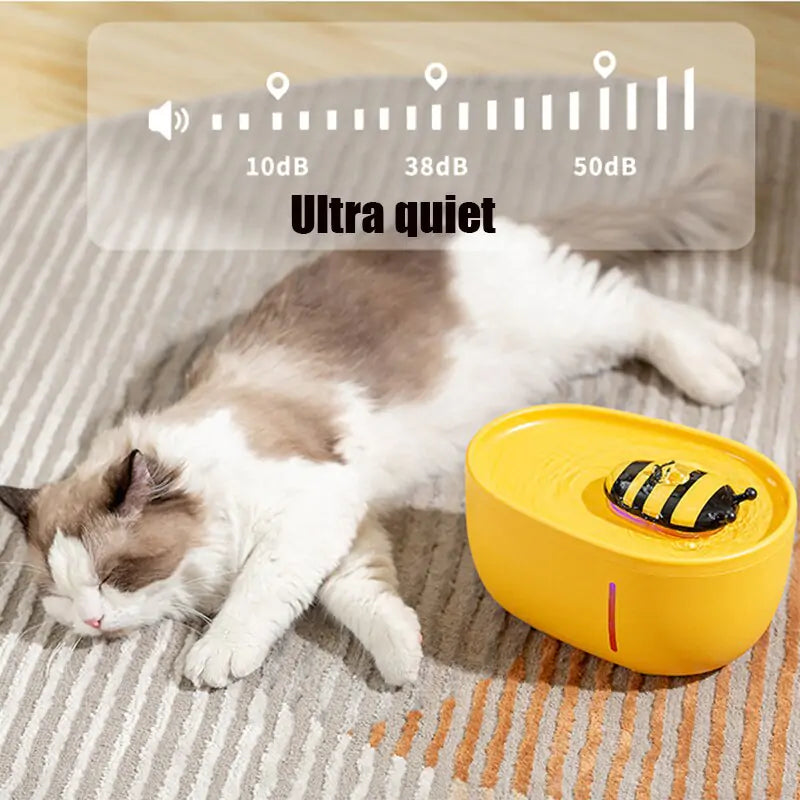A fluffy cat sleeps on a gray and white striped rug next to the Shopinapets Aqua Pet Stream Fountain with a bee decoration, ensuring optimal hydration. Above is a noise graphic labeled Ultra quiet with indicators at 10dB, 38dB, and 50dB.