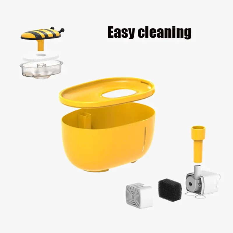 An exploded view of the yellow Aqua Pet Stream Fountain by Shopinapets reveals its components: a bee-shaped lid, transparent water container, main body, filter for pet hydration with purified water, motor, and other parts. Text reads Easy cleaning.