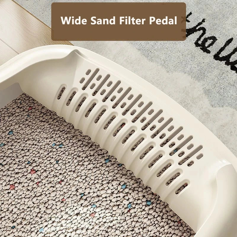 Close-up of a wide sand filter pedal with textured, colorful cat litter inside a beige tray, set against a soft floor backdrop.