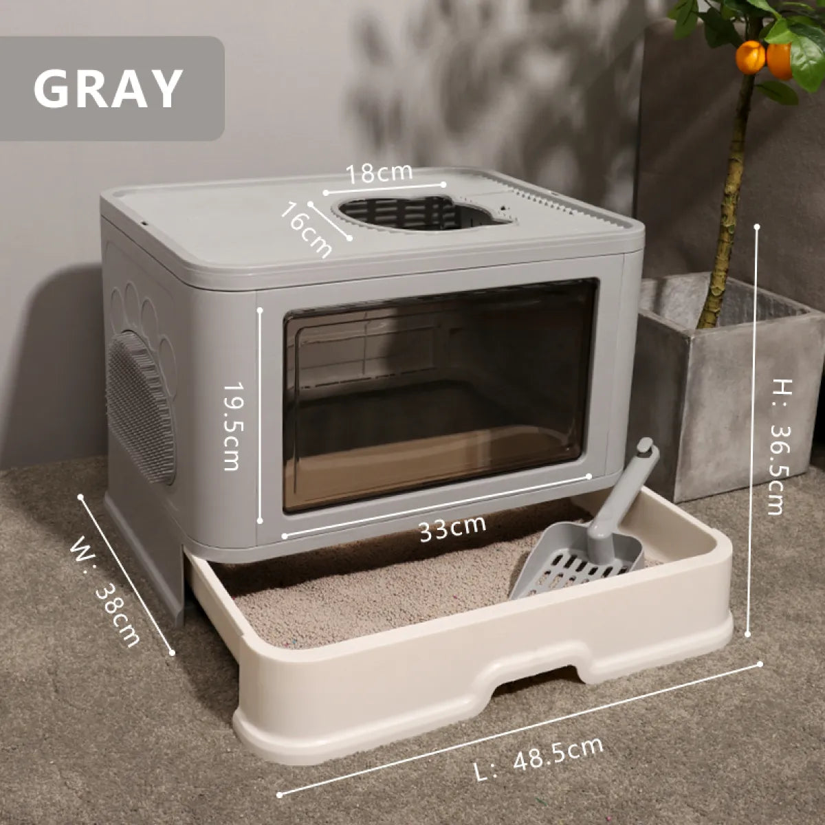 Gray pet litter box with a transparent front, measuring 36.5cm high, 38cm wide, and 48.5cm long, placed beside a potted plant.