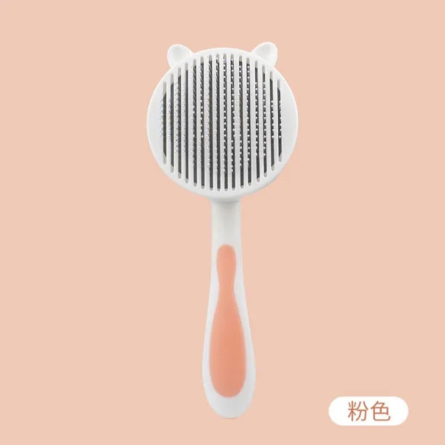 Cute cat-themed grooming brush with a round head, featuring fine comb teeth and a comfortable handle in white and peach colors.
