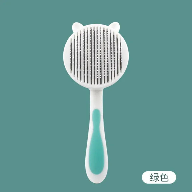 White and teal cat-shaped grooming brush with fine teeth on a round head, set against a solid teal background.