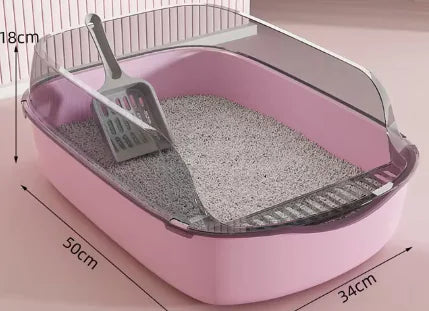 A pink cat litter box with a scoop resting inside, filled with light-colored litter, illuminated softly from above.