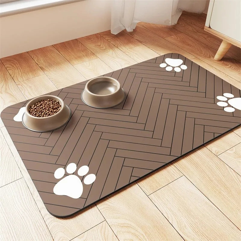 Pet feeding mat with a herringbone pattern, featuring two bowls—one filled with kibble—and white paw prints on a warm brown surface.