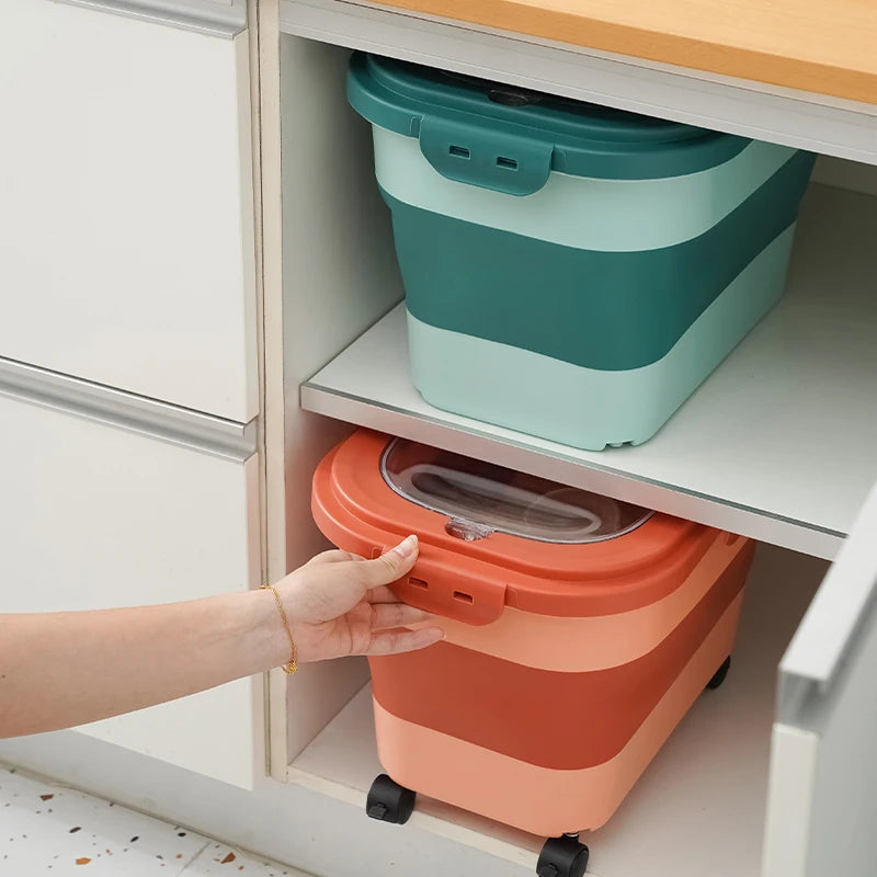 A person reaches for a colorful stackable food storage container in a kitchen cabinet with an open drawer above it.