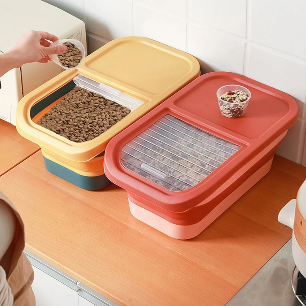 A person pours pet food from a small container into a yellow pet food storage box, surrounded by colorful stacked containers on a countertop.