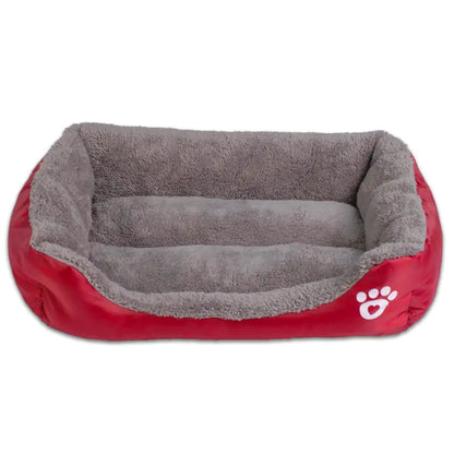 Cozy red pet bed with soft grey lining, featuring raised edges and a paw print design, perfect for pets to rest comfortably.
