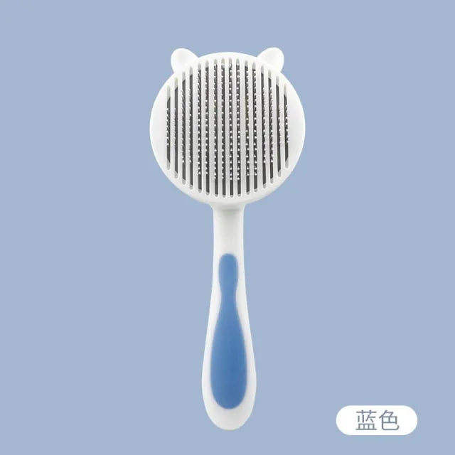 A cute, cat-themed grooming comb with a round, textured head and a comfortable handle in blue and white colors against a light blue background.