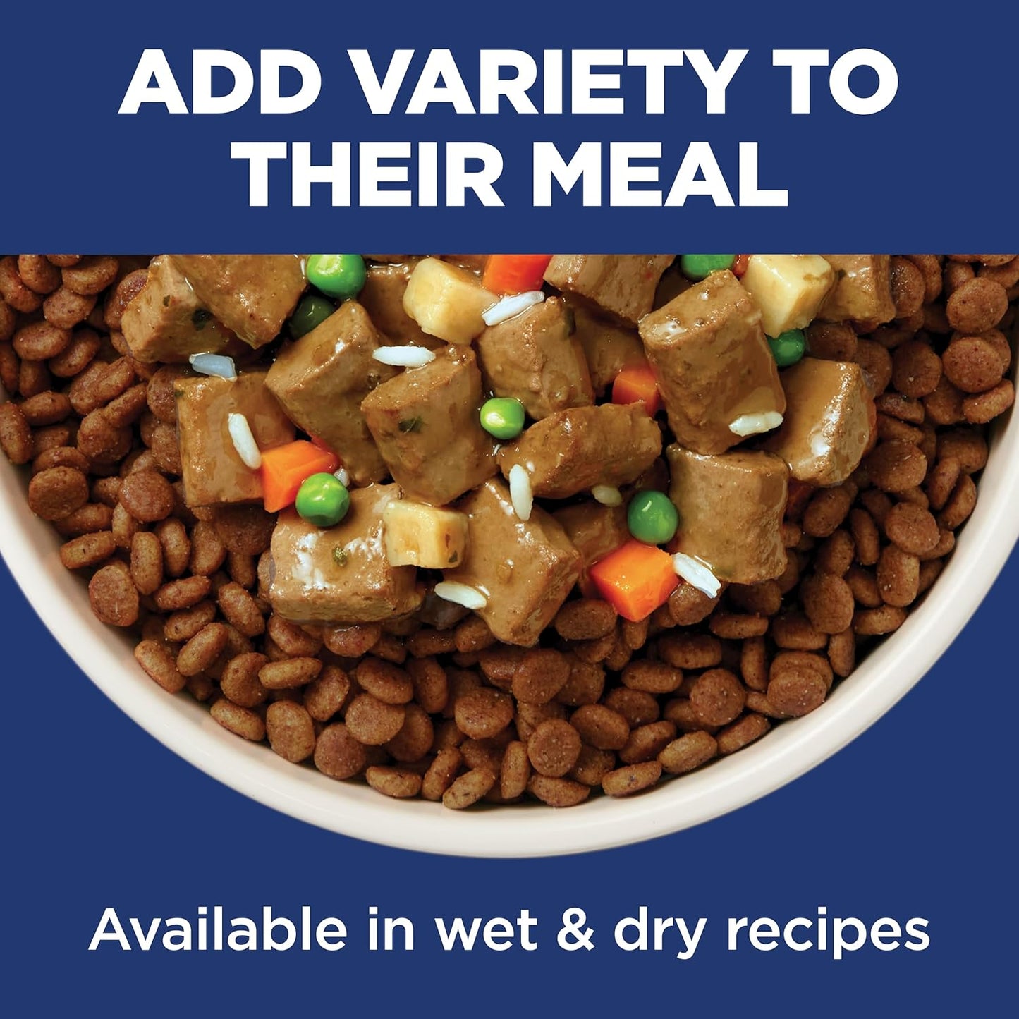 A bowl of dry pet food topped with chunks of savory meat, vegetables, and rice, with a caption promoting meal variety.