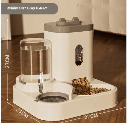 A minimalist gray pet feeder and water dispenser, with a transparent water reservoir and kibble dispensing area, set on a wooden floor.