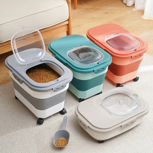Four colorful pet food storage containers with transparent lids and wheels, arranged on a rug beside a scooper.