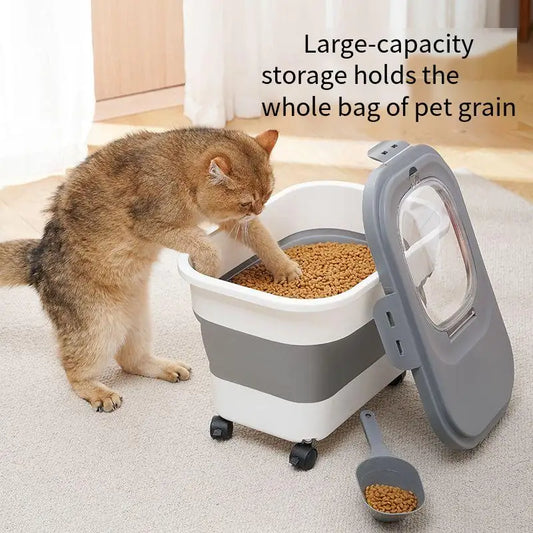 A cat reaches into a large pet food storage container filled with kibble, featuring a scoop and rolling wheels for easy access.
