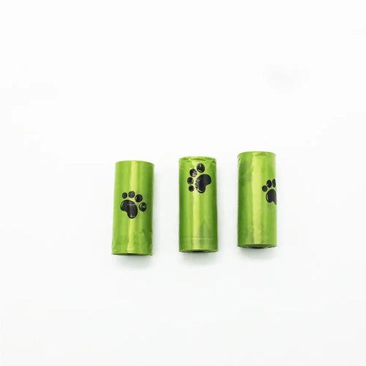Three green pet waste bag rolls with black paw print designs on the sides, arranged side by side on a white background.