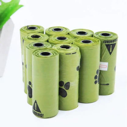 green pet waste bag rolls with black paw print designs on the sides, arranged side by side on a white background.