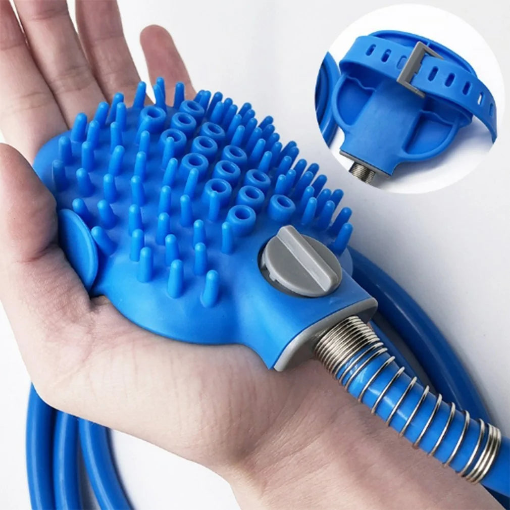 A blue rubber pet grooming glove fits in a hand, featuring numerous soft bristles and a flexible hose attachment for easy use.