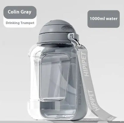 Transparent water bottle labeled "Colin Gray Drinking Trumpet," holding 1000ml, featuring a gray cap and strap.