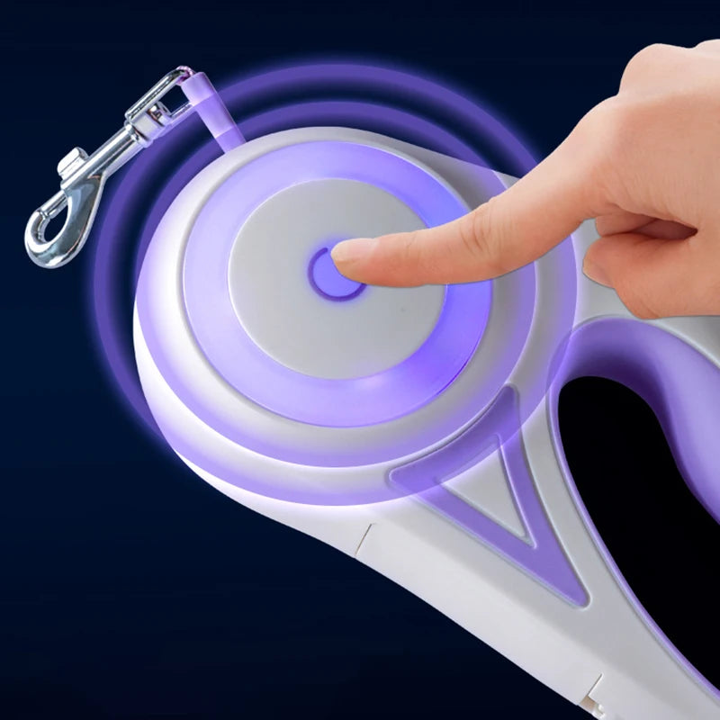 A hand presses a button on a white and purple device with a glowing outline, designed for pet leash retracting.