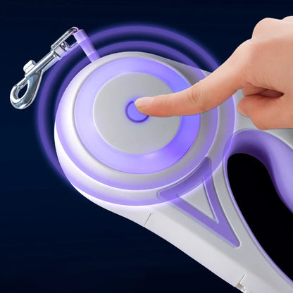 A hand presses a button on a white and purple device with a glowing outline, designed for pet leash retracting.