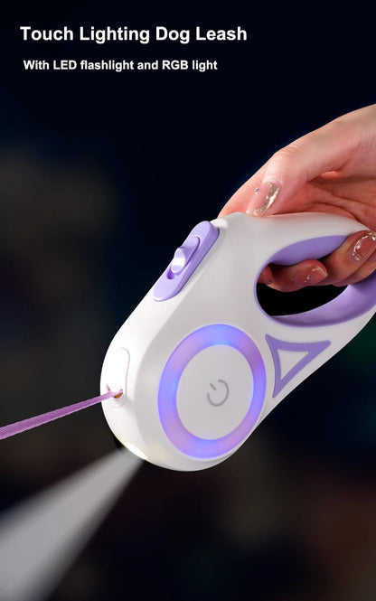 A hand holds a touch-activated dog leash with LED flashlight and RGB light, illuminated in soft purple on a dark background.