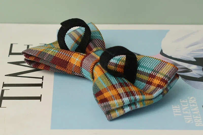 Colorful plaid bow tie with black edges on a magazine background