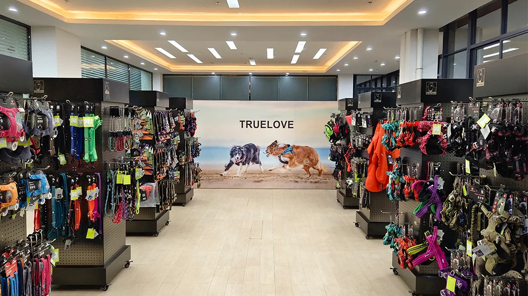Pet store interior with 'TrueLove' branding and pet accessories on display.