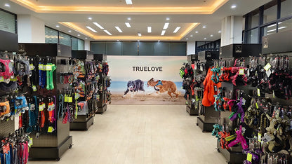 Pet store interior with 'TrueLove' branding and pet accessories on display.