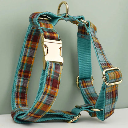 Plaid dog harness with gold hardware on a light gray background