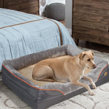 Dog sitting on a large gray pet bed in a bedroom setting.
