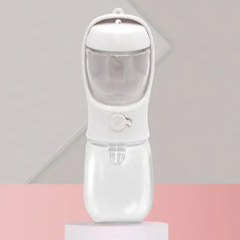 A white, sleek hand-held device with a transparent top, designed for dispensing liquid, placed on a round pedestal.